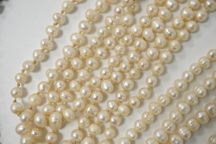 A collection of costume jewellery, comprising: a simulant pearl necklace with a green and colourless paste clasp; a fringe necklace set with circular-cut pastes; three strands of cultured pearls; a Royal Artillery cap ba